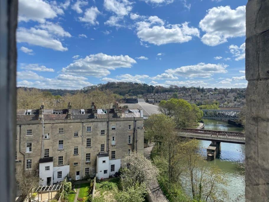 a view of a river with a bridge and buildings at Crescent Penthouse with Stunning Views and free parking in Bath