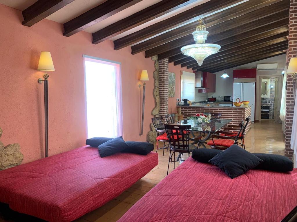 ein Wohnzimmer mit 2 Betten und ein Esszimmer in der Unterkunft Casa vacacional en plena naturaleza in Pacs del Penedes