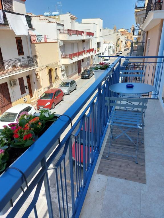 d'un balcon avec une table et une vue sur la rue. dans l'établissement Levante, à Terrasini