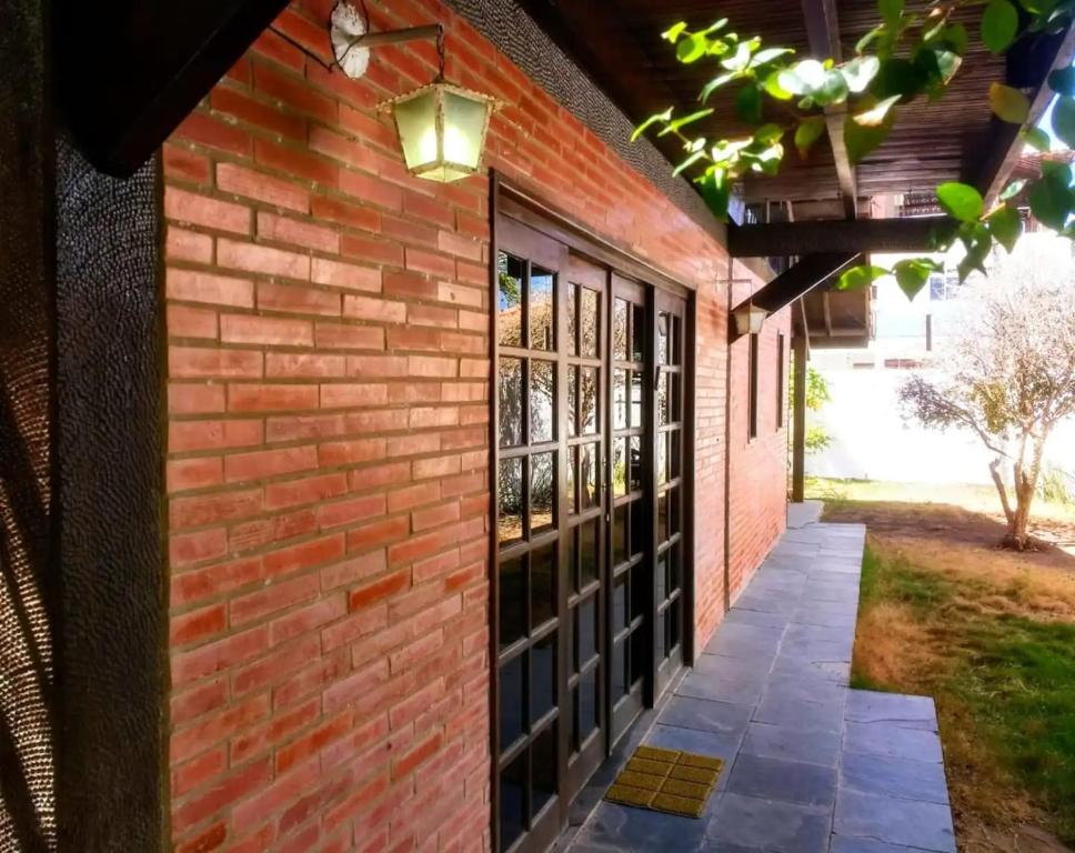 ein Backsteingebäude mit einer Tür und Fenstern in der Unterkunft CASA CAMPESTRE COM PISCINA in Cabedelo