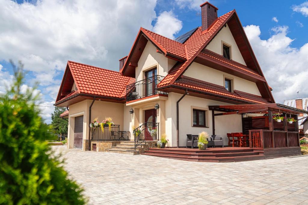 a house with a red roof at Noclegi Na Brzegu in Szaflary