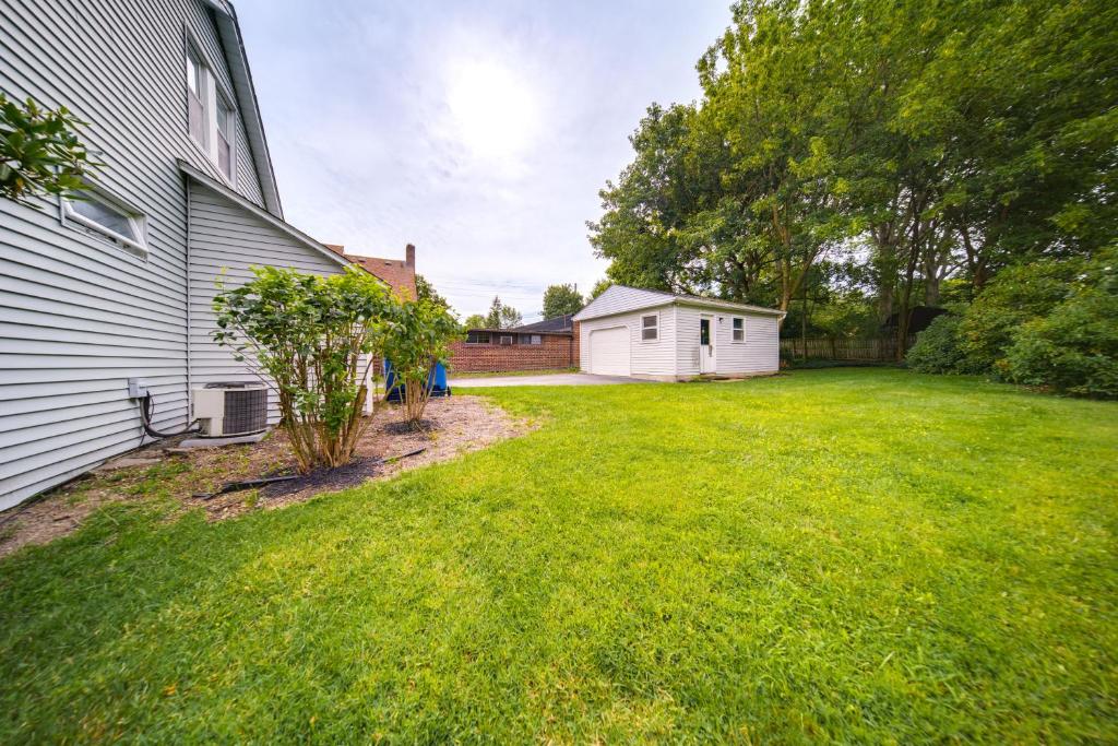 a yard next to a house with a tree at Welcoming Willoughby Home 1 Mi to Historic Dtwn in Willoughby
