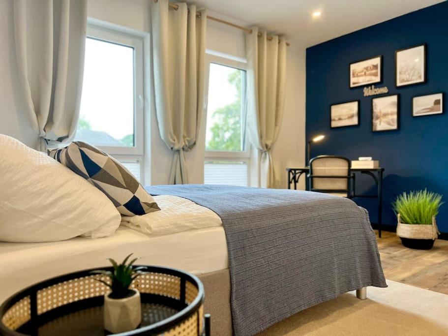 a bedroom with a large bed with blue walls at Große Wohnung Wellness + Sauna + Netflix in Petershagen