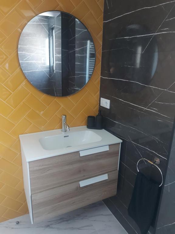 een badkamer met een wastafel en een spiegel bij Apartamento JARDIN DELUZ, con Wifi y Parking privado gratis in Santander