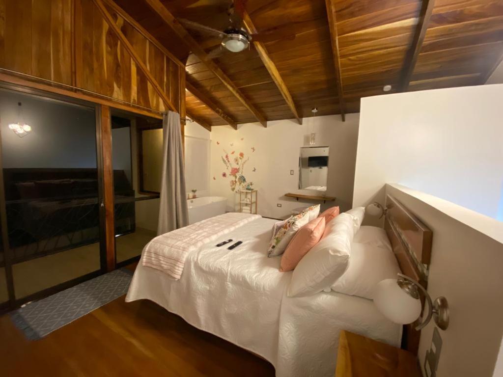 Schlafzimmer mit einem Bett mit weißer Bettwäsche und Kissen in der Unterkunft Villas Flakis, Luna in Monteverde Costa Rica