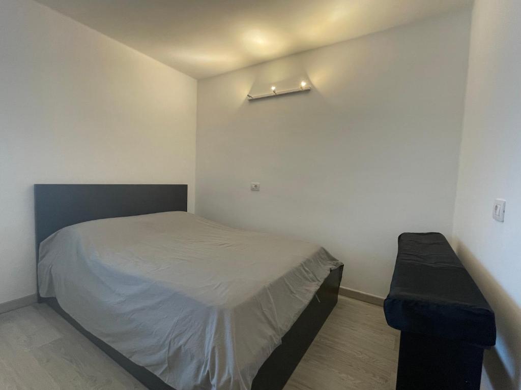 een kleine slaapkamer met een bed en een bank bij Apartamento con Piscina en Golf del Sur in San Miguel de Abona