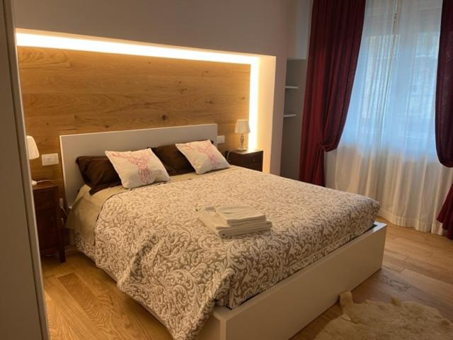 una camera con un grande letto con testiera in legno di Appartamento Isa a Tarvisio