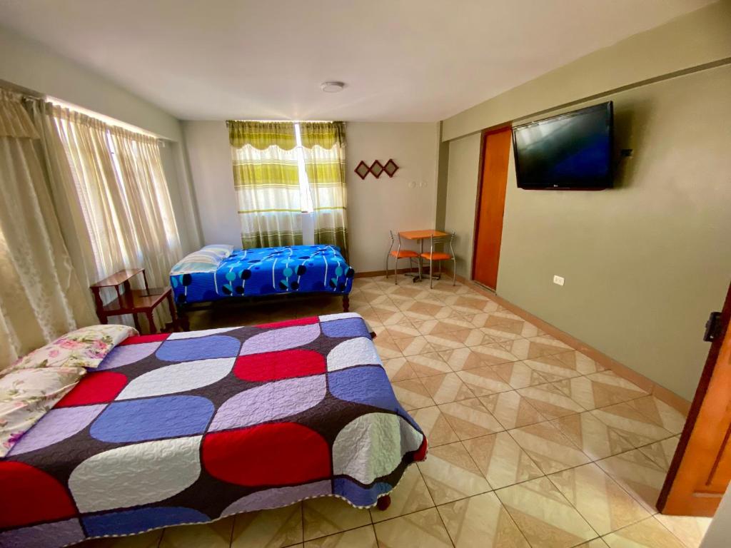 1 dormitorio con 1 cama y TV de pantalla plana en Hospedaje Miranda, en Chimbote