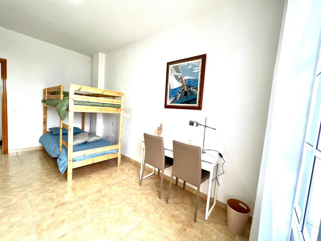 Pokój ze stołem i łóżkiem piętrowym w obiekcie Little Home w mieście Puerto del Rosario
