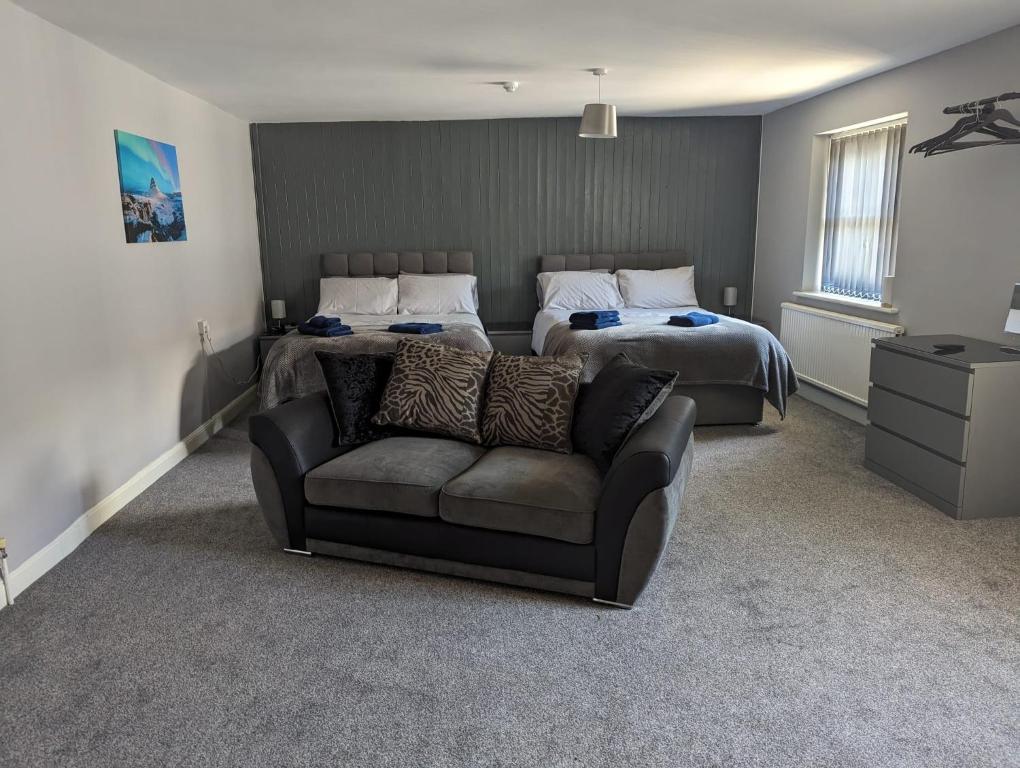 a bedroom with two beds and a couch and a bed at Kings Head in Chepstow