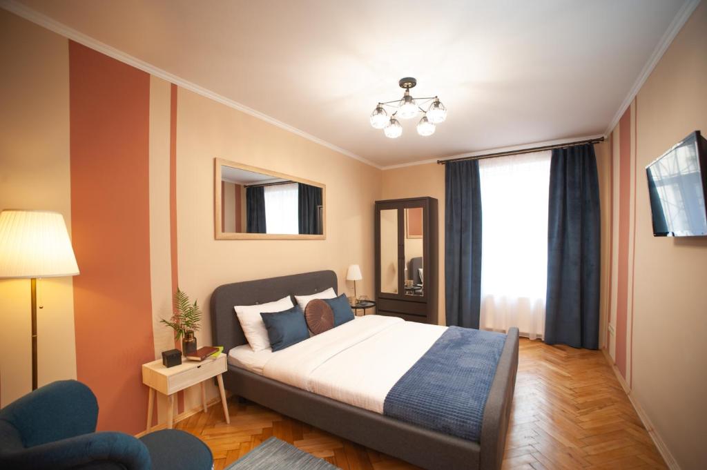 リヴィウにあるRomantic Suite, 3mins to Rynok Squareのベッドルーム1室(ベッド1台、椅子、窓付)