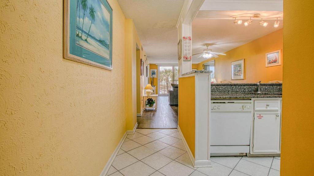 cocina con paredes amarillas y electrodomésticos blancos en Destin on the Gulf 201 - Beach Front Property, en Destin