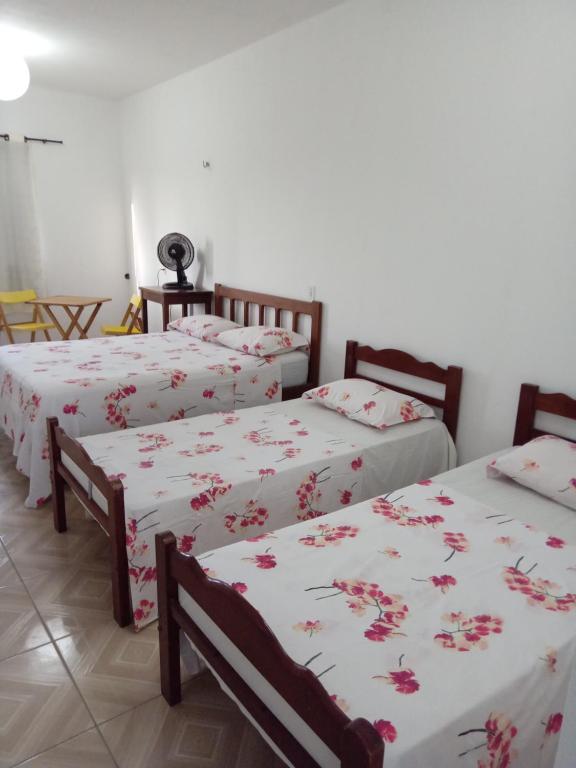 un grupo de 3 camas en una habitación en O Farol Aluguel de Quartos en Beberibe