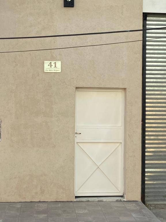 uma porta de garagem branca do lado de um edifício em Departamentos del Estero em Santiago del Estero