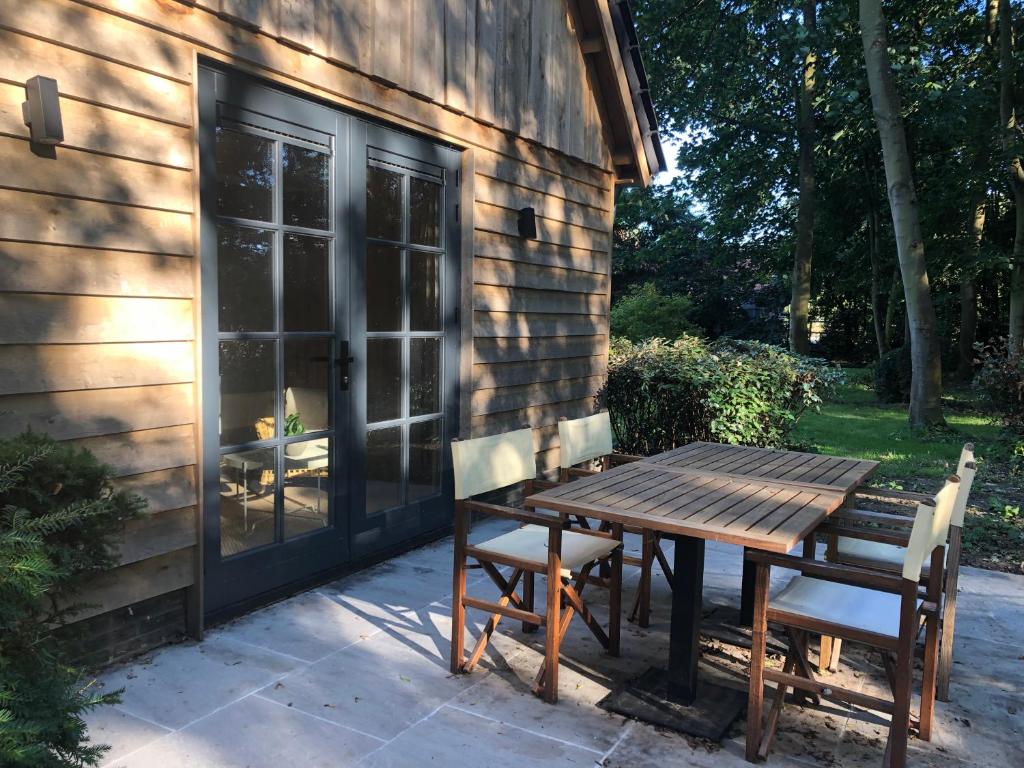 una mesa de madera y sillas fuera de una casa en Grevelingenhuys, en Scharendijke