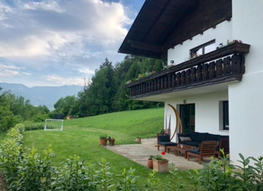 a house with a balcony and a bench in a yard at Home Sweet Vacation Home in Ledenitzen