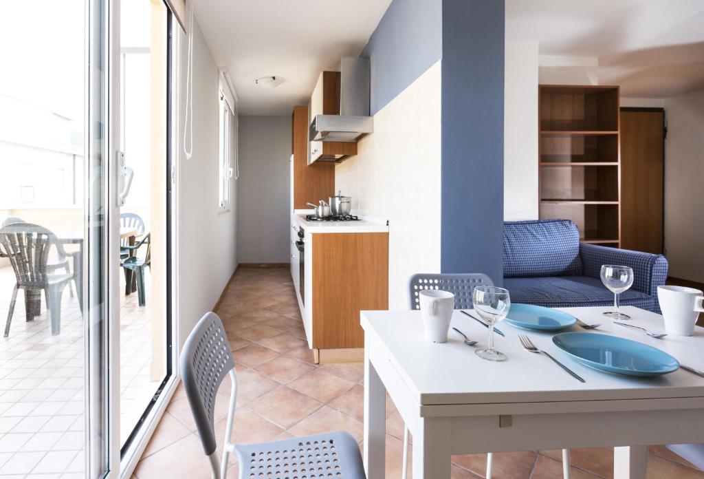 Il comprend un salon avec une table et des chaises ainsi qu'une cuisine. dans l'établissement Residence Del Sole, à Rimini