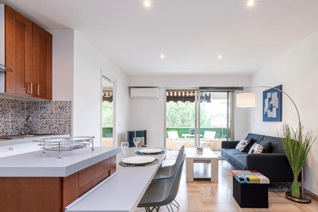 a kitchen and living room with a table and a couch at Antipolis in Cros-de-Cagnes