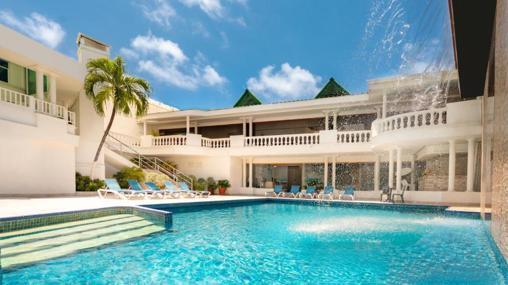 a swimming pool in front of a house at Hotel Americas San Andres Islas Colombia in San Andrés