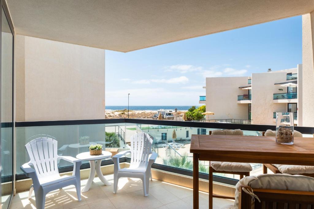 balcón con mesa, sillas y vistas al océano en Casa Lilia en Cotillo