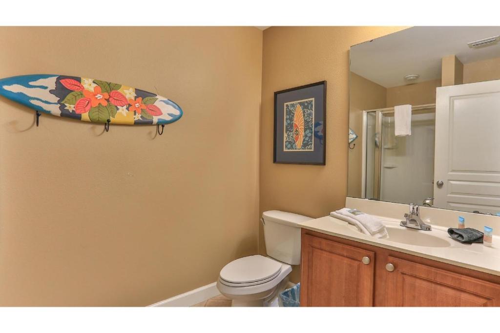ein Bad mit einem WC und einem Surfbrett an der Wand in der Unterkunft Beach Resort 507 - Great Views Beautiful Decor Zero Entry Pool in Destin