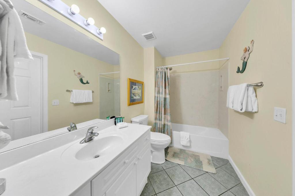 ein weißes Badezimmer mit Waschbecken und Toilette in der Unterkunft Amalfi Coast 113B - Steps from the Beach 2BD 2BA in Destin