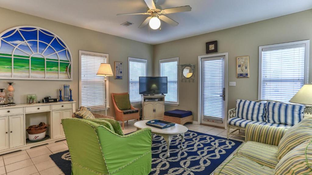 ein Wohnzimmer mit Couch und Fernseher in der Unterkunft Biglows Bungalow - About a quarter mile to PRIVATE Neighborhood Beach Access, Pet Friendly, Community Pool in Destin