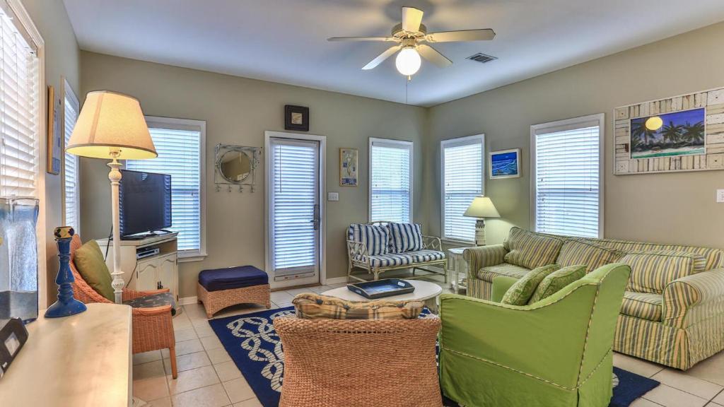 ein Wohnzimmer mit Couch und Fernseher in der Unterkunft Biglows Bungalow - About a quarter mile to PRIVATE Neighborhood Beach Access, Pet Friendly, Community Pool in Destin