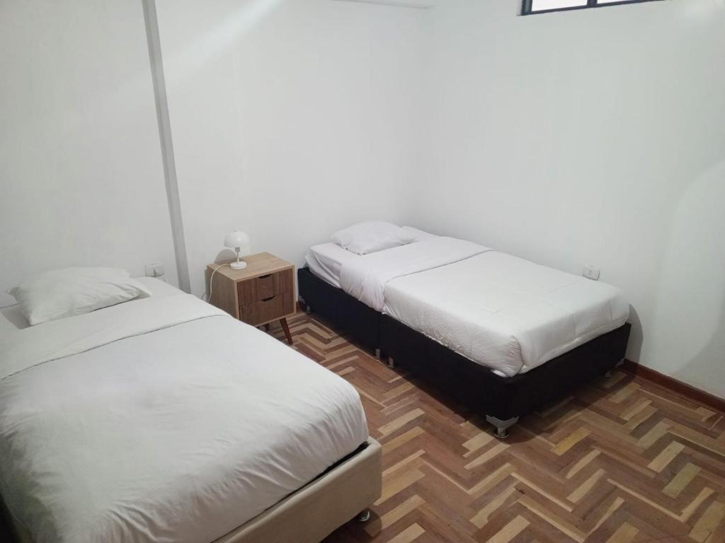 um quarto com duas camas e uma mesa de cabeceira em DEPARTAMENTO AMOBLADO EN CUSCO em Cusco