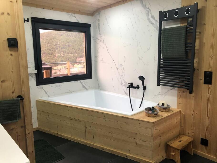 a large wooden tub in a bathroom with a window at Chalet au pied des pistes du Cambre d Aze in Saint-Pierre-dels-Forcats