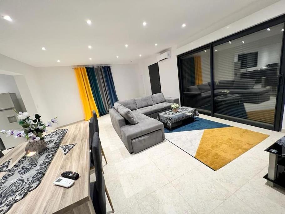 een woonkamer met een bank en een tafel bij Maison centre-ville in Penta-di-Casinca