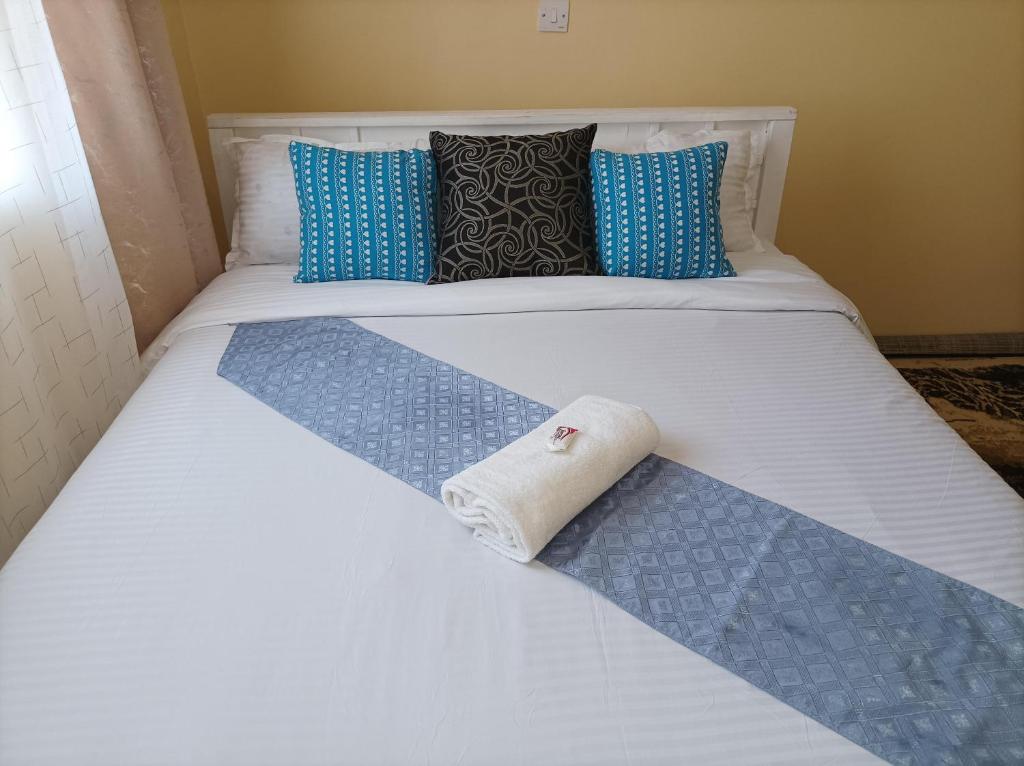 Una cama con una toalla enrollada. en Devine 1 bedroom on Moi Southlake road en Naivasha