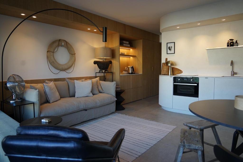 uma sala de estar com um sofá e uma mesa em Studio23 Knokke em Knokke-Heist