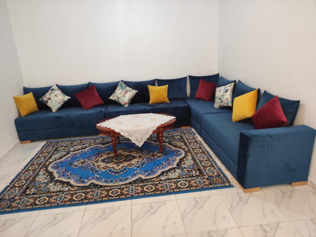 Sofá azul con almohadas coloridas y mesa en Sotto ma carino, en Temara