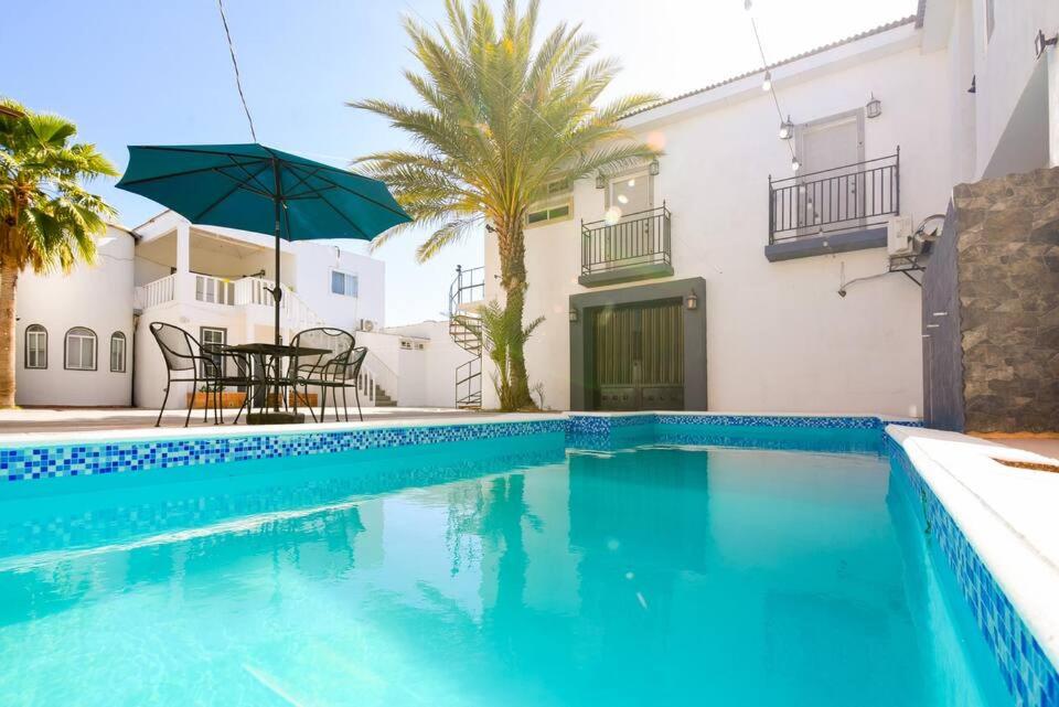 una piscina azul con mesa y sombrilla en 01 Departamento-alberca-playa-céntrico en Puerto Peñasco