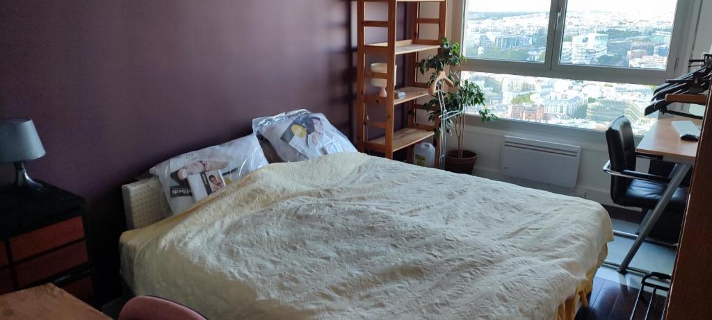 a bedroom with a bed in a room with a window at Full apt - Top floor - Eiffel Tower Panoramic View in Issy-les-Moulineaux