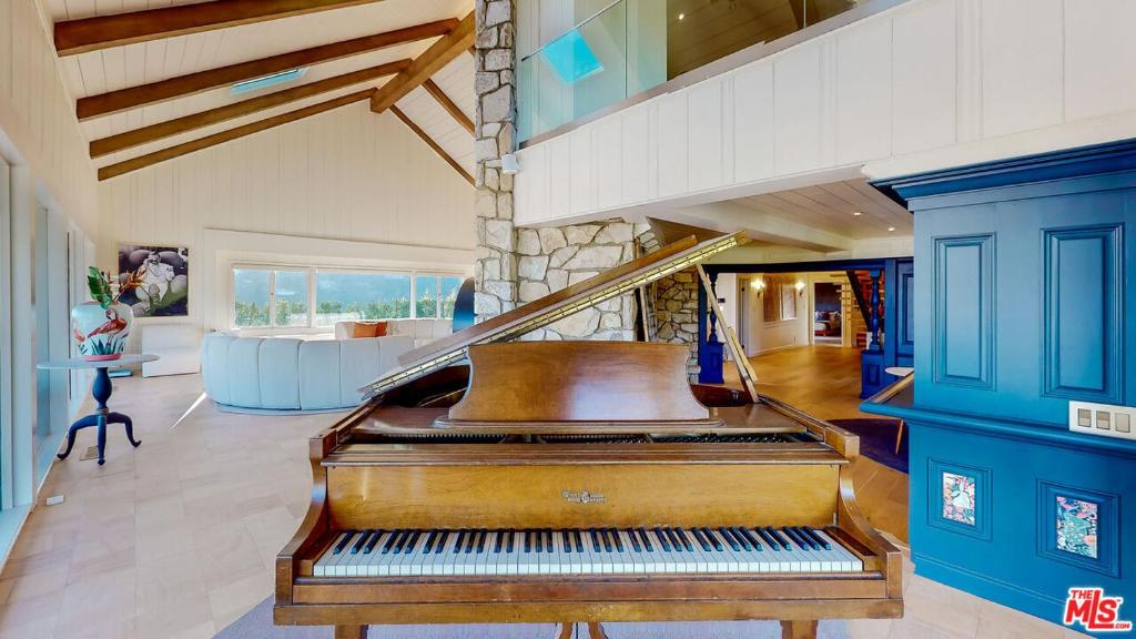 a piano in a room with a blue wall at Beverly Estates in Los Angeles