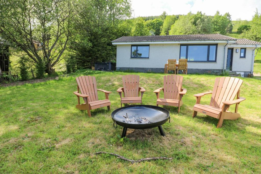 a group of chairs and a fire pit in a yard at Beech Cottage in Aberfeldy