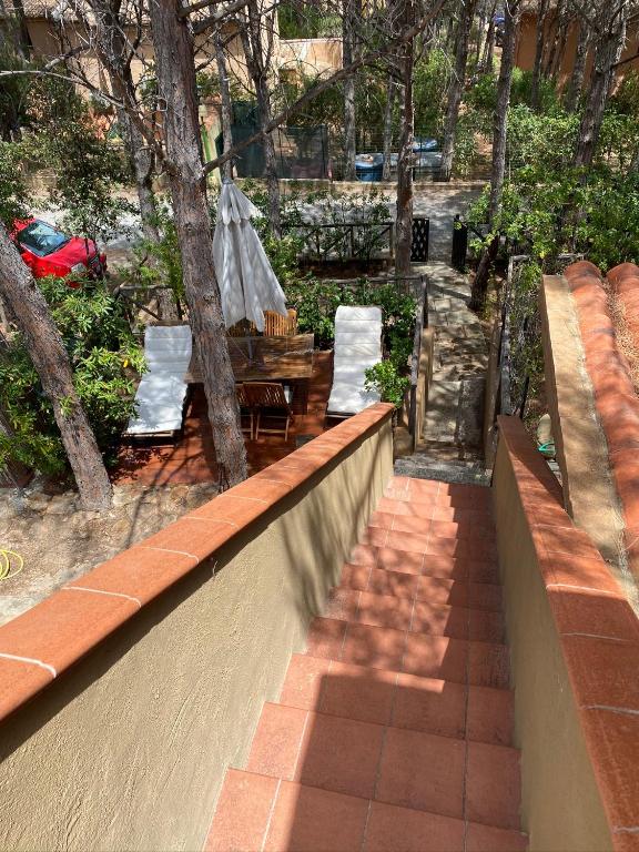 a patio with a table and chairs and trees at House pinus village in Forte Village