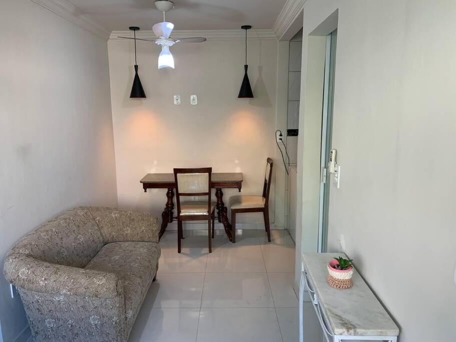 Quitinete Aconchegante Prq Pelinca في كامبوس دوس جويتاكازيس: غرفة معيشة مع أريكة وطاولة