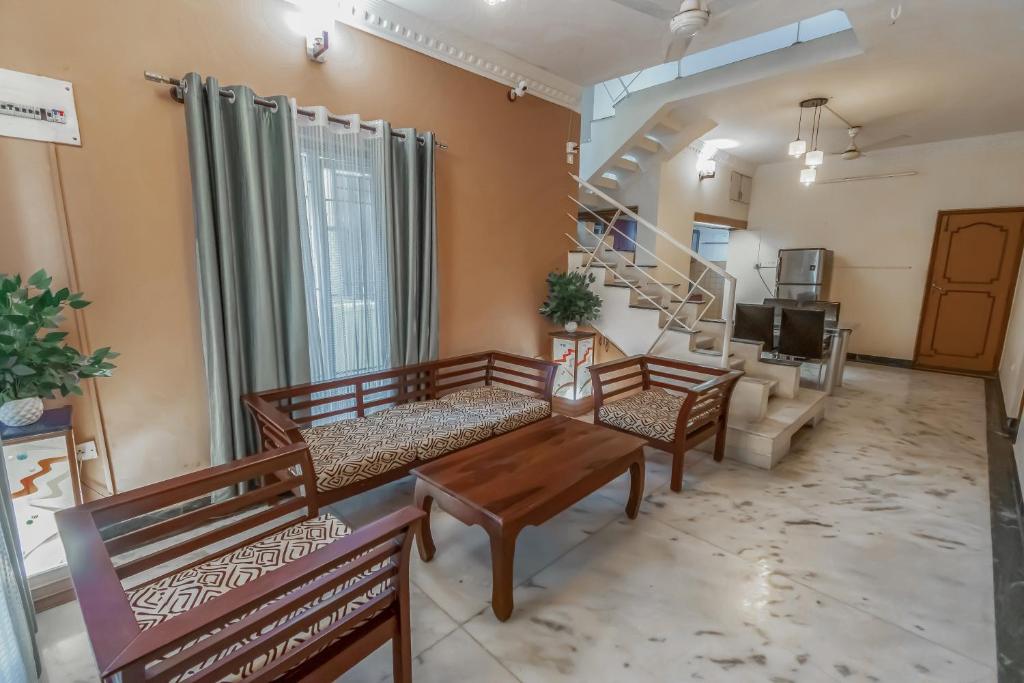 een woonkamer met banken, een tafel en een trap bij HomeSlice Yellow in Bangalore