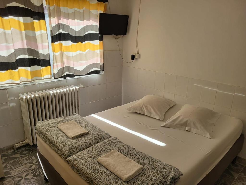 a small room with two beds and a radiator at Gara de Nord-Banat-4-You in Bucharest