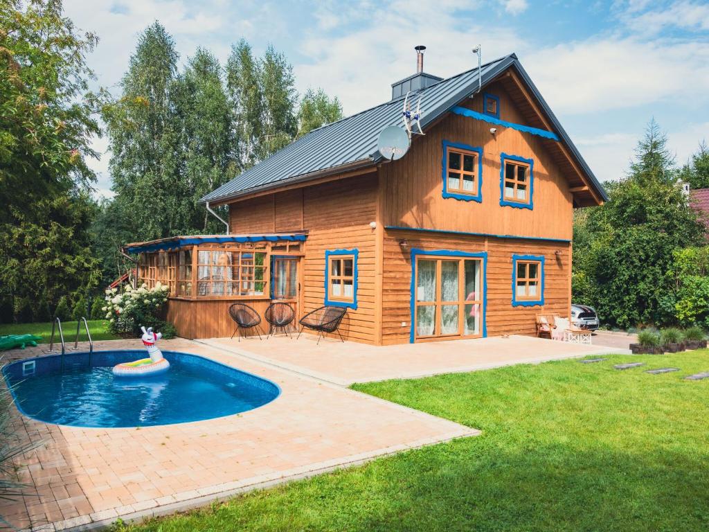 a log house with a pool in front of it at Large holiday villa with sauna, jacuzzi and pool in Perlino