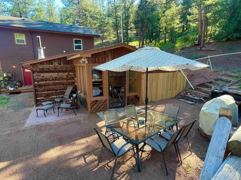 a patio with a table and chairs and an umbrella at Deckers South Platte River Cabin 