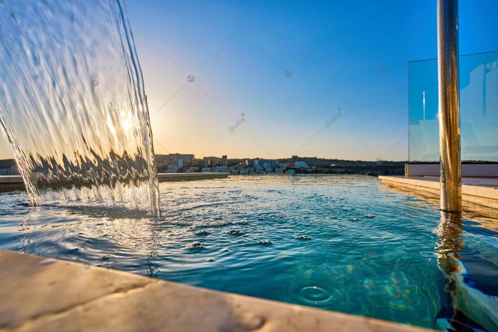 una fontana in cima a una piscina d'acqua di Lux Villa with Pool-Hosted by Sweetstay a San Pawl il-Baħar