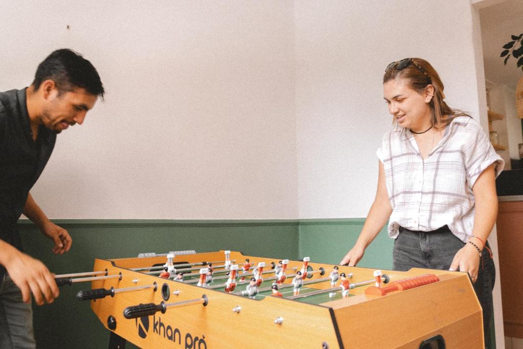 a man and a woman playing a game of chess at Cordova Hostel Medellin in Medellín