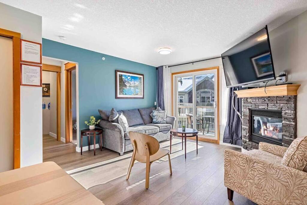 Lux 2BR 5BD Suite Mountain view! في كانمور: غرفة معيشة مع أريكة ومدفأة