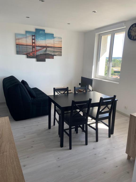 ein Esszimmer mit einem schwarzen Tisch und Stühlen in der Unterkunft Appartement 21 in La Roche-Posay