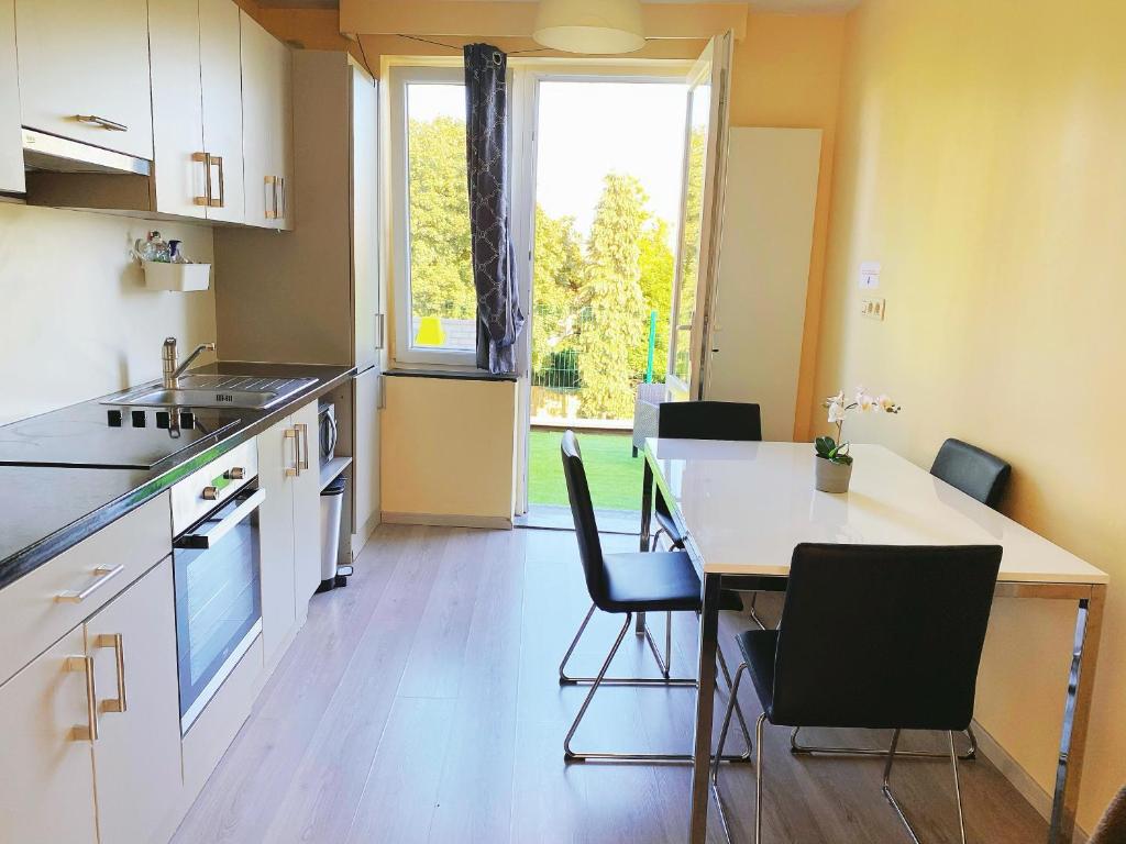 cocina con mesa, sillas y ventana en Sweet home en Bruselas