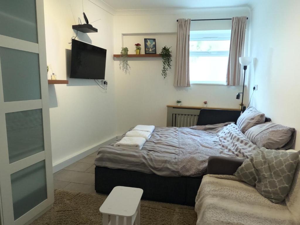a bedroom with a bed and a couch at Studio Apartment in Kew in Kew